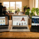 Three laptops on a Lagos office desk displaying a free template, a premium theme, and a custom-built DST website, side by side.